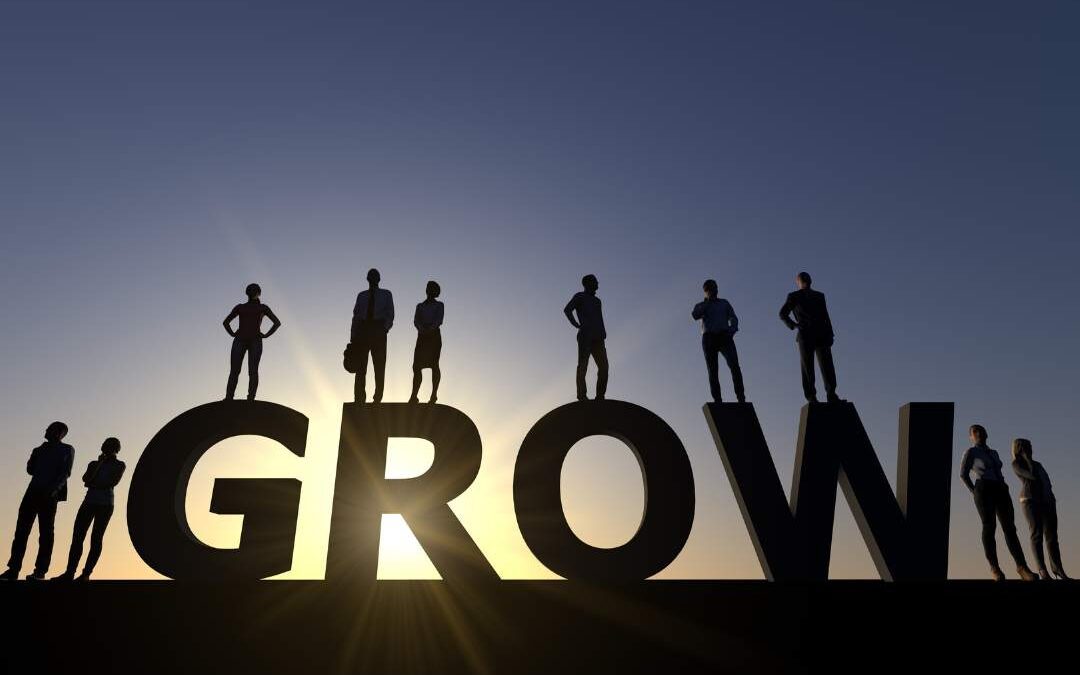 A group of people standing above the word "GROW".